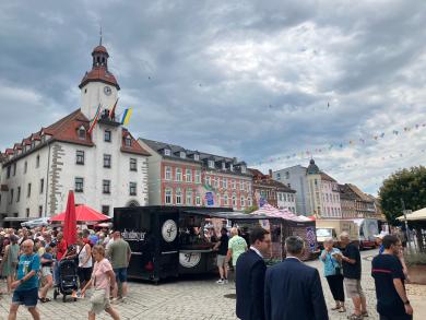 Der belebte Marktplatz und im Hintergrund das Schmöllner Rathaus mit Beflaggung